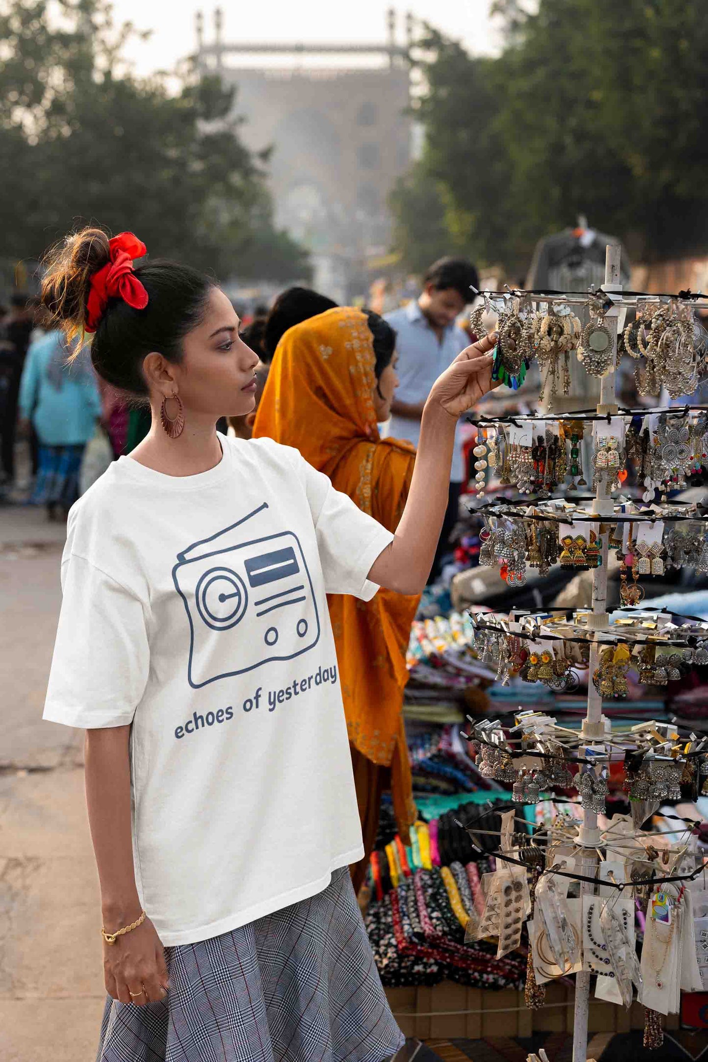 Woman in white oversized t-shirt with retro radio print at market