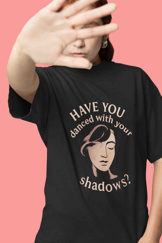 Close-up of a model in a black oversized tee with “Have You Danced With Your Shadows?” graphic